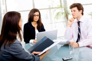 Three young businespeople working in team at office, smiling.